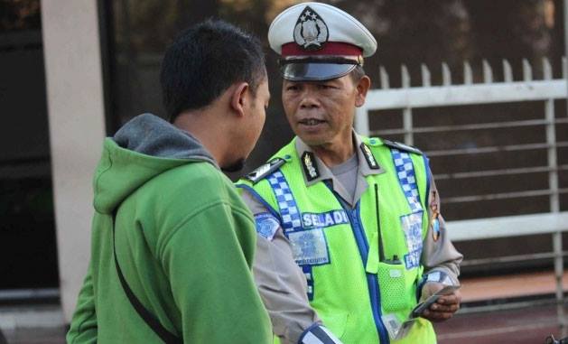Bripka Seladi saat mengatur lalu lintas | Foto: Merdeka