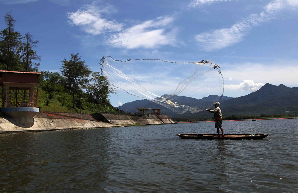 Seorang warga terlihat mencari ikan di Waduk Selorejo. Istimewa/Agus Trimukti/Humas PLN/detikFoto.