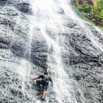 Seorang pengunjung nampak memanjat tebing air terjun di Coban Slimpring. (Foto: Instagram @explorekasembon)