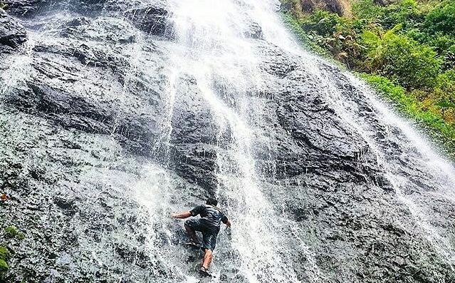 Seorang pengunjung nampak memanjat tebing air terjun di Coban Slimpring. (Foto: Instagram @explorekasembon)